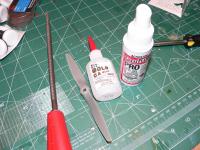 Name: P1010025.jpg
Views: 1401
Size: 129.9 KB
Description: I use a little Ca and kicker to glue in the spacer then I can do the reaming right away without the spacer popping out.  The tool with the red handle is called a rat tail file. :)