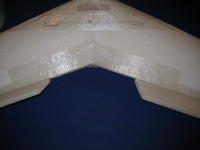 Name: RC5 042.jpg
Views: 1887
Size: 54.0 KB
Description: The weakest place on the plane is the trailing edge between the elevons.  The shock string helps to reinforce this area and I also put extra tape here top and bottom.