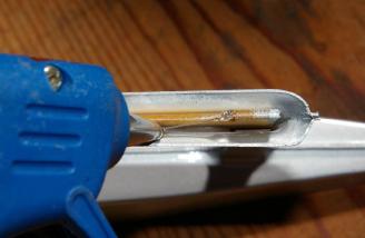 Filling the tip float mounting channel with hot glue.