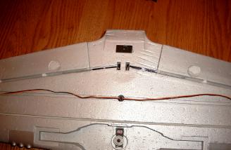 Here is a close look at the bottom of the wing that shows the retract servo and flap torque rods installed.  The aileron servo wires follow channels on the bottom of the wing before passing thru a hole to the top.