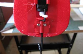A small plastic piece clips into place and is secured with two screws to retain the nose gear.