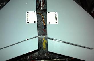 Once the servos were glued to the covers, I routed the wires through a channel I dug and screw the plates in place.