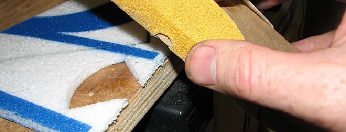Careful use of a razor blade or Xacto knife results in a straighter edge here than sanding.