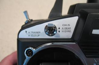 Channel 5 switch and three position trainer/Idle up switch. The three position switch is unique in that is has a positive click stop to actuate the function or can be pulled beyond the stop where it can be held in training mode.