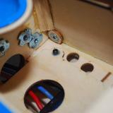 The assembly bolts on one end and <i>keys</i> into a fuselage former on the other to fully secure the tray.